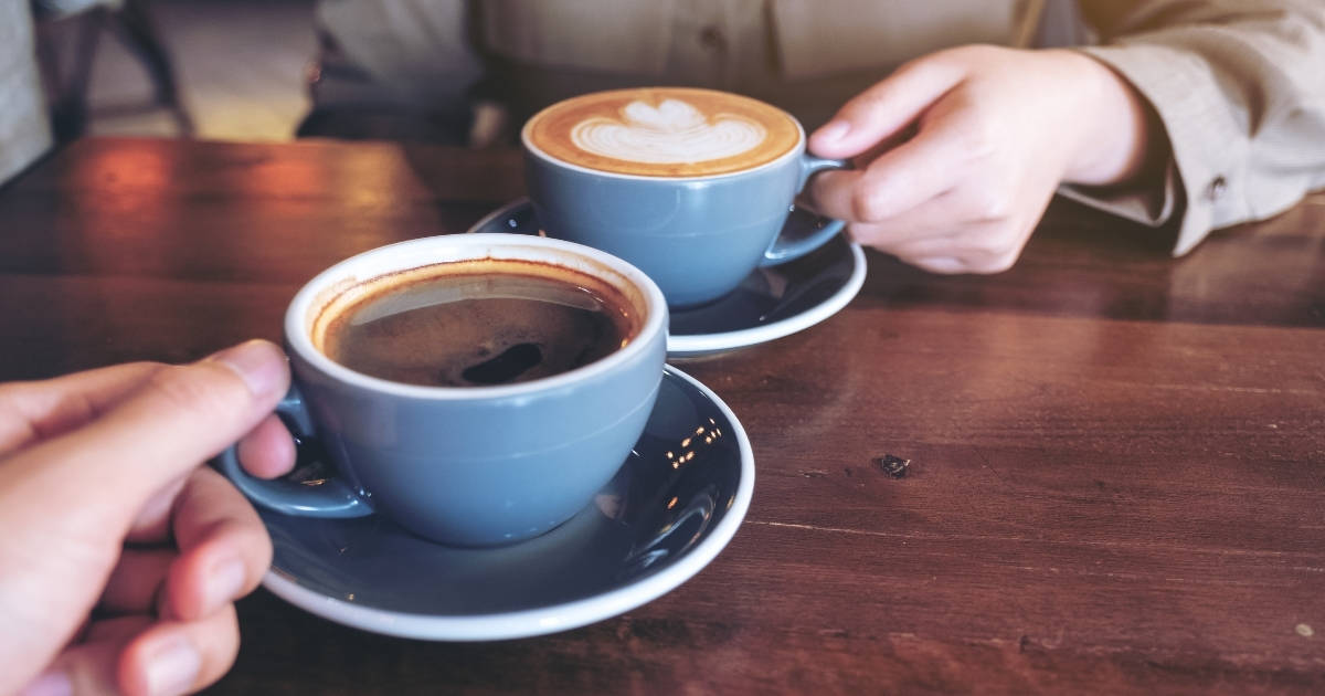 Two women with a cup of coffee on table